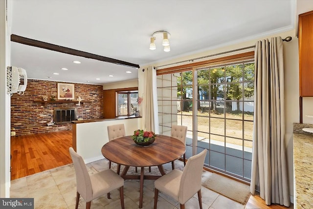 dining space with light tile patterned floors, brick wall, recessed lighting, ornamental molding, and a brick fireplace