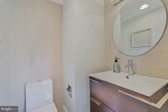 bathroom with recessed lighting, toilet, and vanity