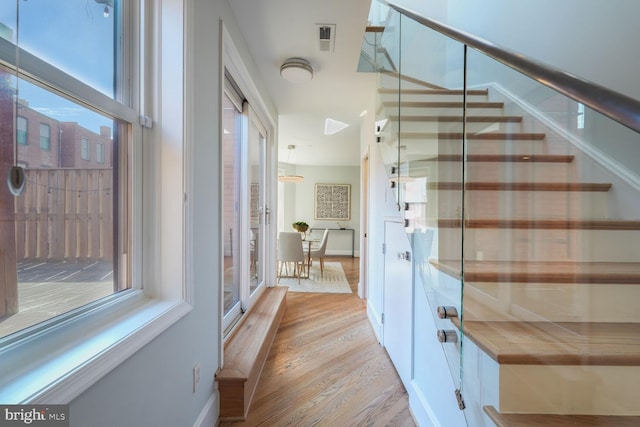 staircase featuring visible vents, baseboards, and wood finished floors