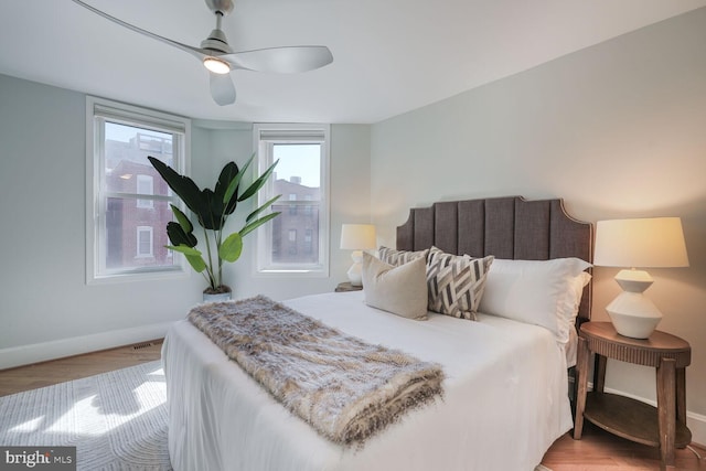 bedroom with baseboards, light wood-type flooring, and ceiling fan