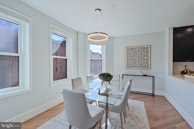 dining space featuring light wood-style flooring and baseboards