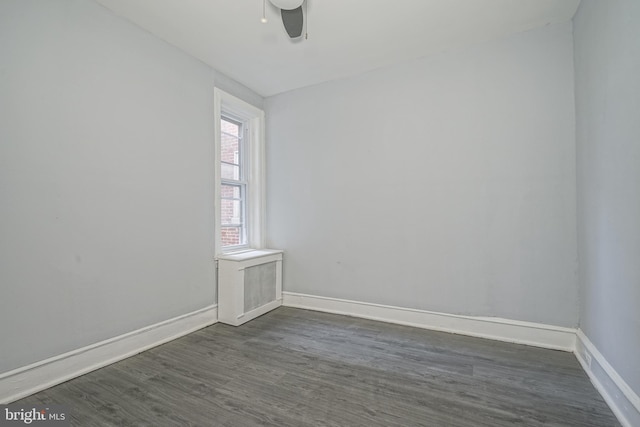 empty room with baseboards, dark wood-style floors, and a ceiling fan