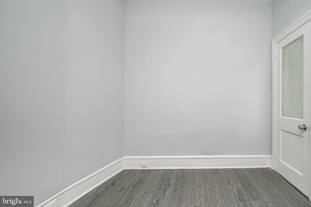 empty room with baseboards and dark wood-style flooring