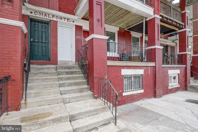 doorway to property featuring brick siding