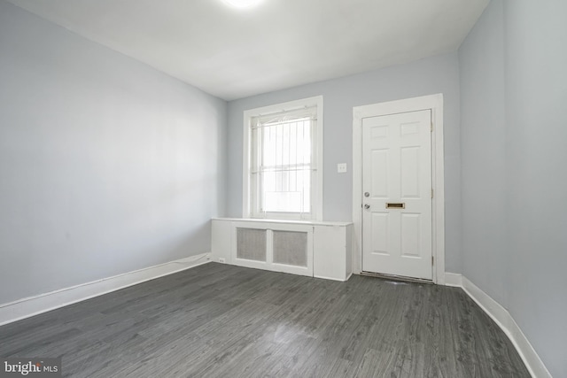 interior space featuring dark wood-type flooring and baseboards