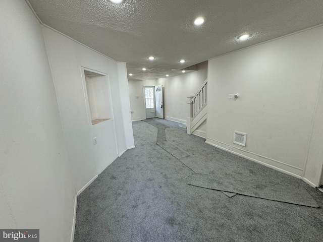 carpeted empty room with visible vents, recessed lighting, a textured ceiling, and stairs