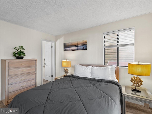 bedroom featuring a textured ceiling and wood finished floors