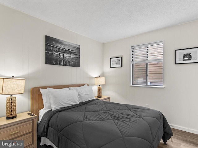 bedroom featuring a textured ceiling and wood finished floors