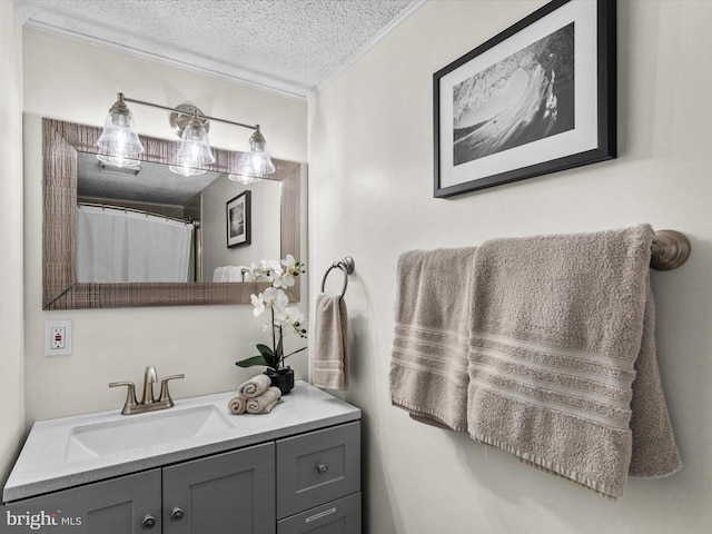 full bath with vanity, a textured ceiling, and crown molding