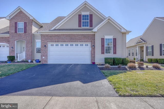 traditional-style house with aphalt driveway, brick siding, and a front lawn