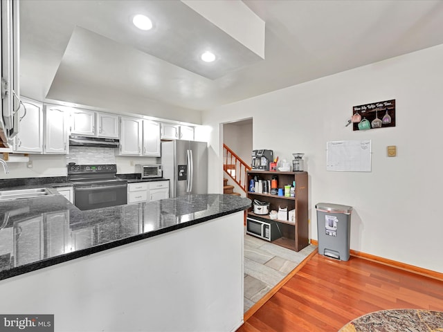 kitchen featuring light wood-type flooring, a sink, under cabinet range hood, black / electric stove, and stainless steel fridge with ice dispenser