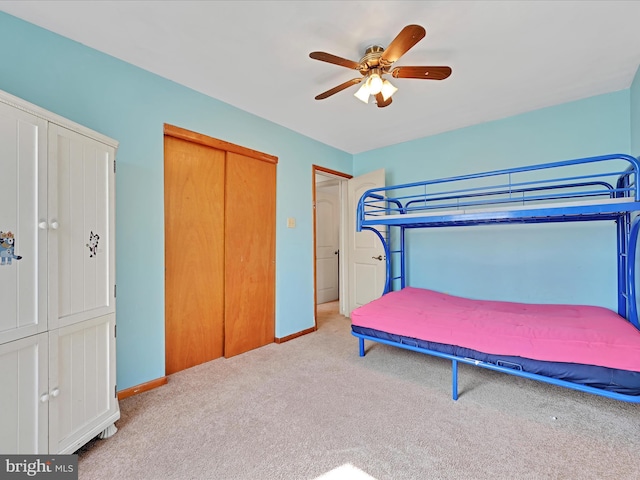 bedroom with a closet, carpet flooring, ceiling fan, and baseboards