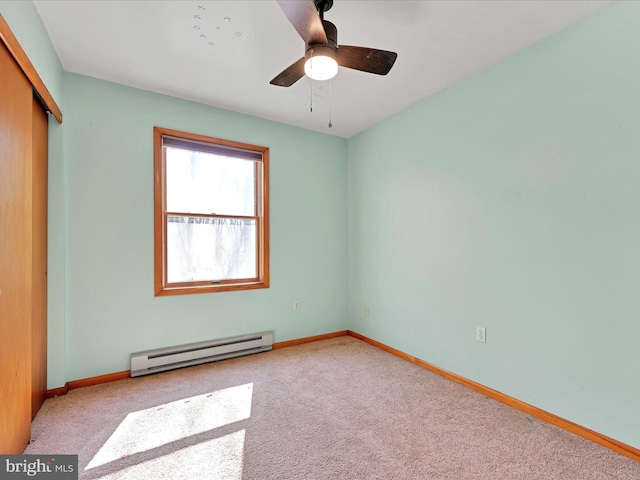 unfurnished bedroom featuring a closet, carpet floors, baseboard heating, and baseboards