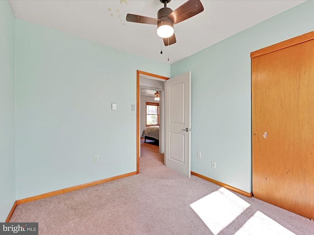 unfurnished bedroom featuring a closet, ceiling fan, baseboards, and carpet floors