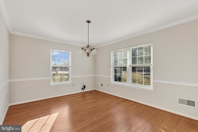 unfurnished dining area featuring a notable chandelier, visible vents, baseboards, and hardwood / wood-style floors