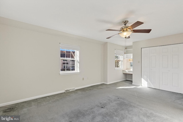 unfurnished bedroom with a ceiling fan, baseboards, visible vents, carpet floors, and a closet