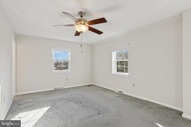 empty room with plenty of natural light, carpet, and visible vents