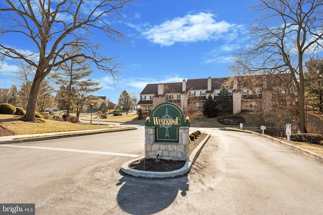 view of road featuring curbs, a residential view, and a gated entry