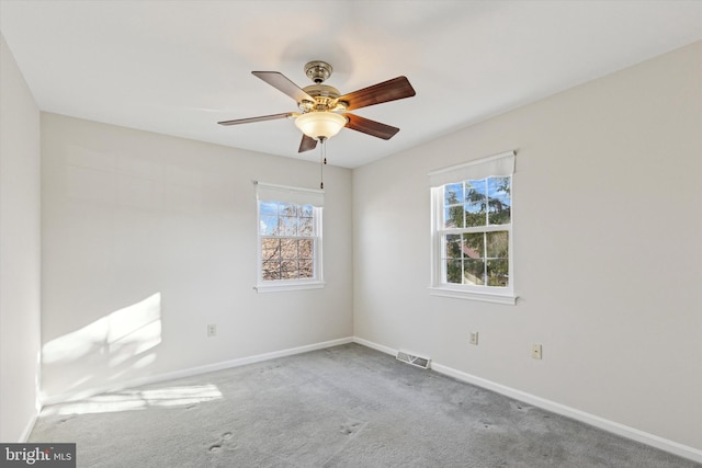 spare room with visible vents, baseboards, carpet, and a ceiling fan