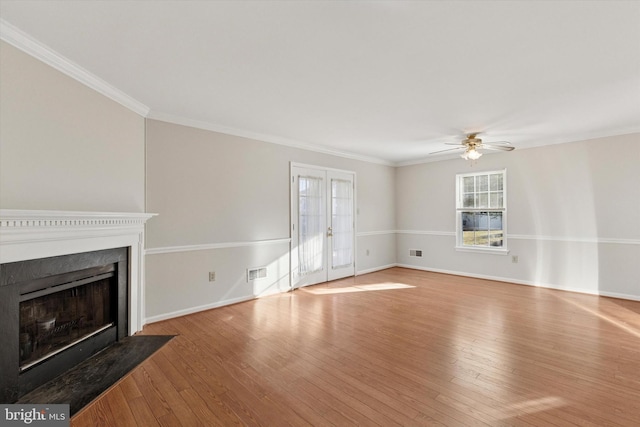 unfurnished living room with hardwood / wood-style floors, a fireplace with flush hearth, visible vents, and ornamental molding