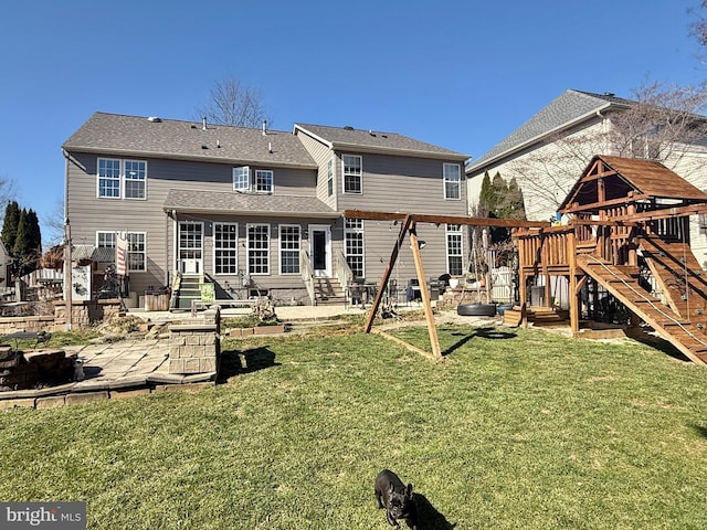 rear view of property featuring a patio, a lawn, a playground, and entry steps