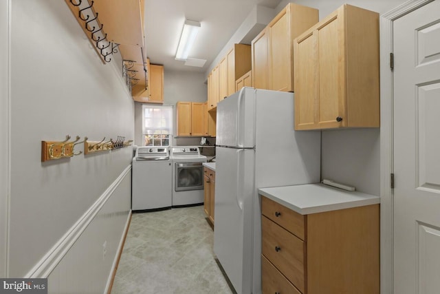 kitchen with light countertops, freestanding refrigerator, light brown cabinets, and washer and clothes dryer