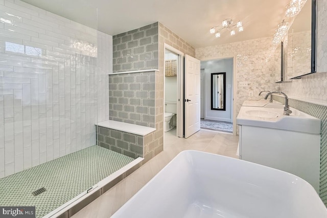 bathroom with toilet, double vanity, tiled shower, a soaking tub, and a sink