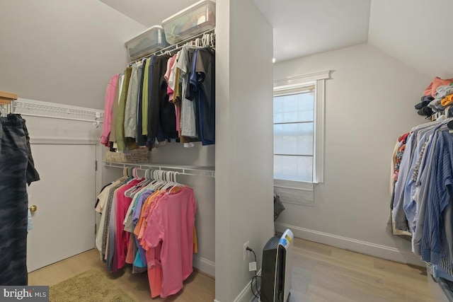 walk in closet with lofted ceiling and wood finished floors