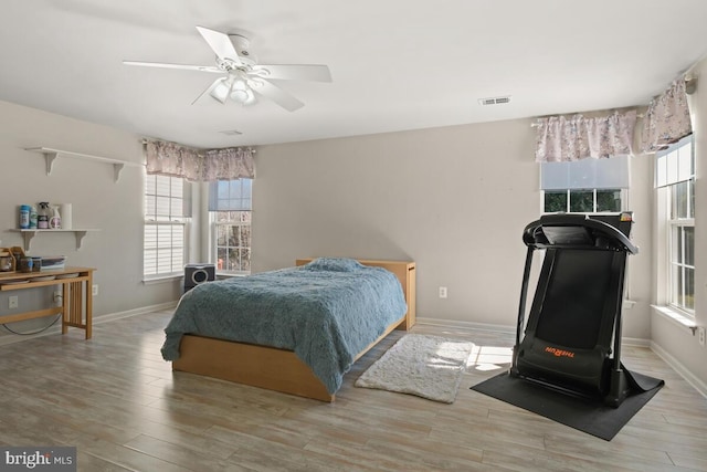 bedroom featuring visible vents, multiple windows, and wood finished floors