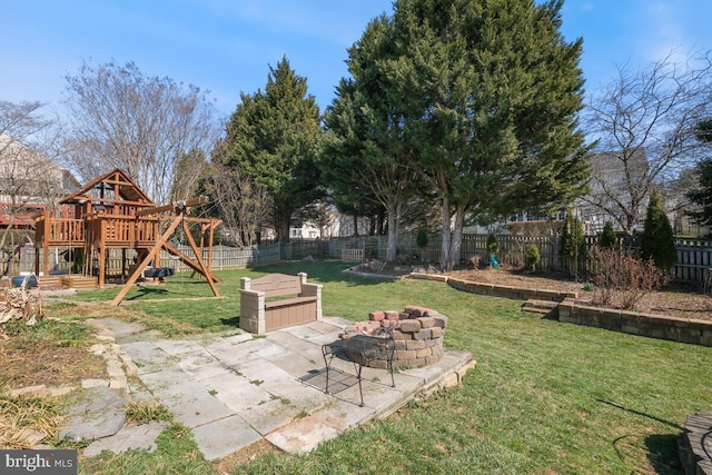 view of yard featuring a patio area, a playground, and a fenced backyard