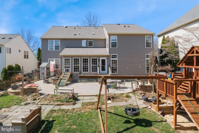 back of house with a patio, a playground, a fire pit, and fence