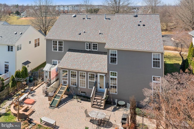 back of house with entry steps, a patio, fence, and roof with shingles