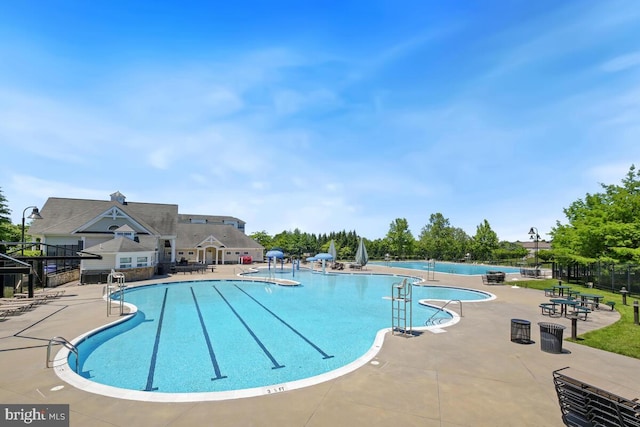 community pool featuring a patio and fence