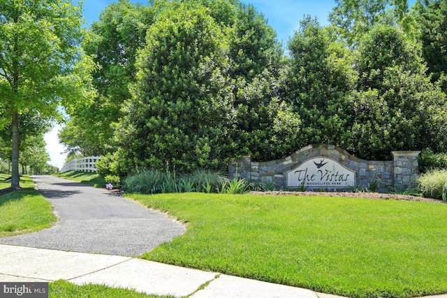 community / neighborhood sign featuring a lawn