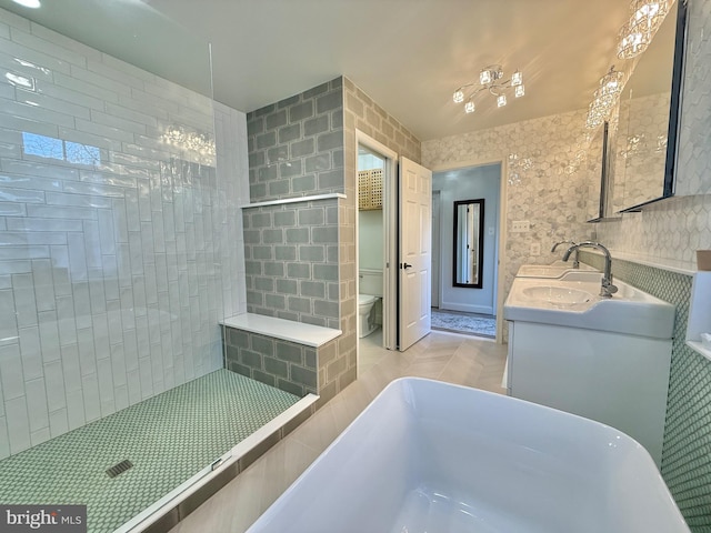 bathroom with a freestanding tub, toilet, a sink, a tile shower, and double vanity