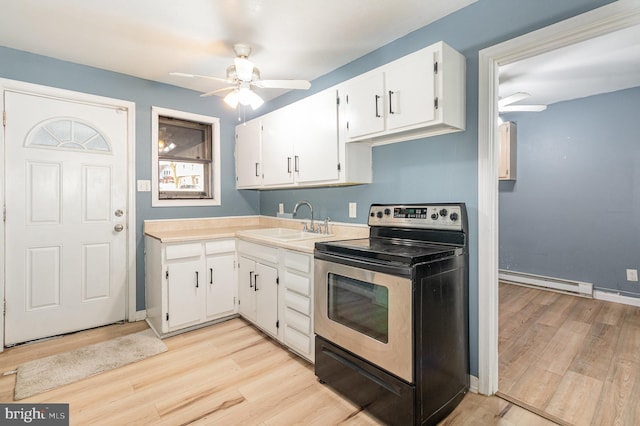 kitchen featuring a ceiling fan, a sink, white cabinetry, stainless steel range with electric cooktop, and a baseboard radiator