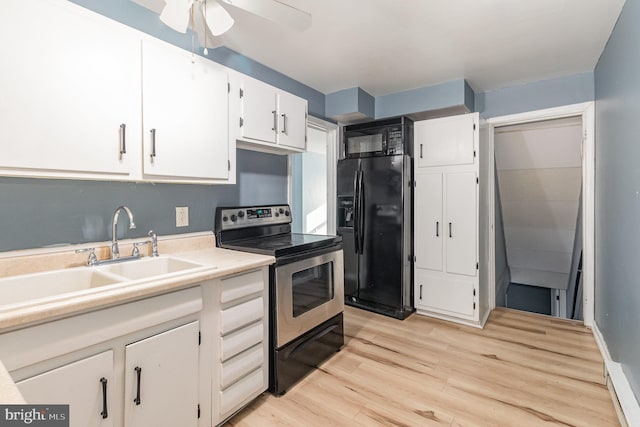 kitchen with light wood-style flooring, a sink, black appliances, white cabinets, and light countertops