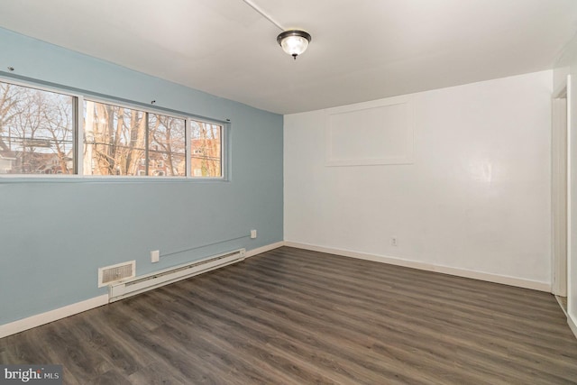 empty room with a baseboard heating unit, dark wood-type flooring, baseboards, and visible vents