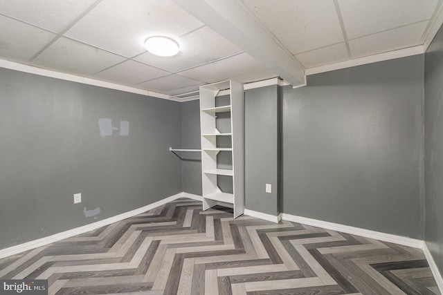 finished basement with a drop ceiling and baseboards