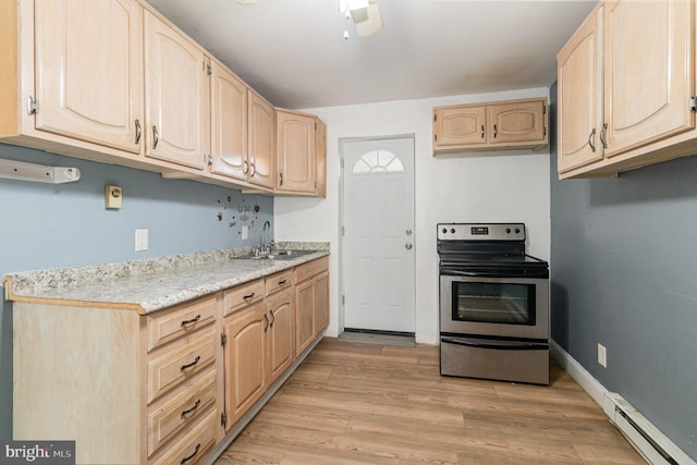 kitchen with light wood finished floors, a baseboard heating unit, light brown cabinetry, stainless steel electric stove, and a sink