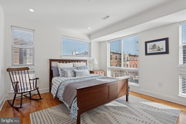 bedroom with light wood-style flooring, recessed lighting, baseboards, and visible vents