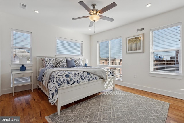 bedroom with recessed lighting, multiple windows, and wood finished floors