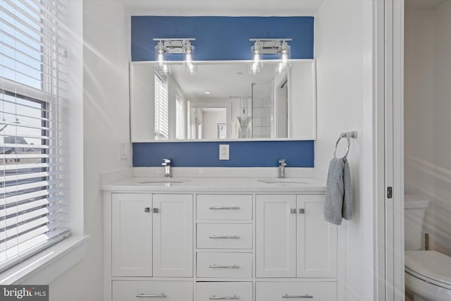 full bath with plenty of natural light, toilet, and a sink