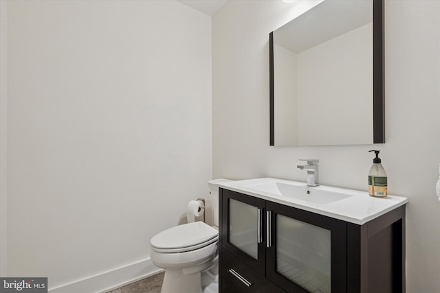 bathroom featuring vanity, toilet, and baseboards