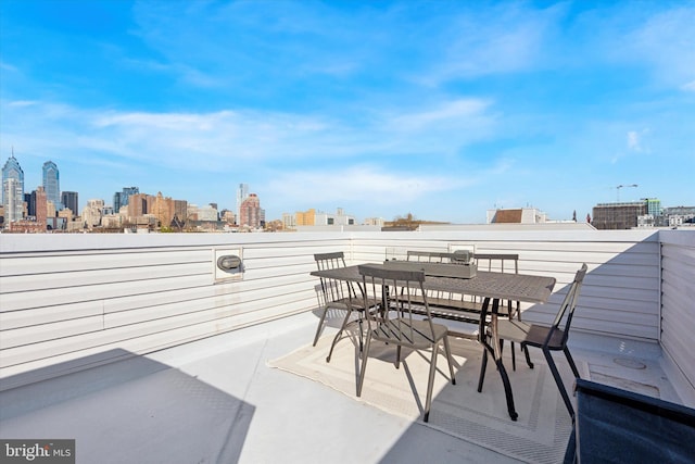 view of patio / terrace featuring a city view, outdoor dining area, and a balcony