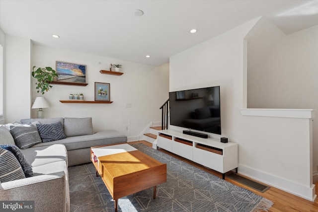 living room featuring stairway, recessed lighting, wood finished floors, and baseboards