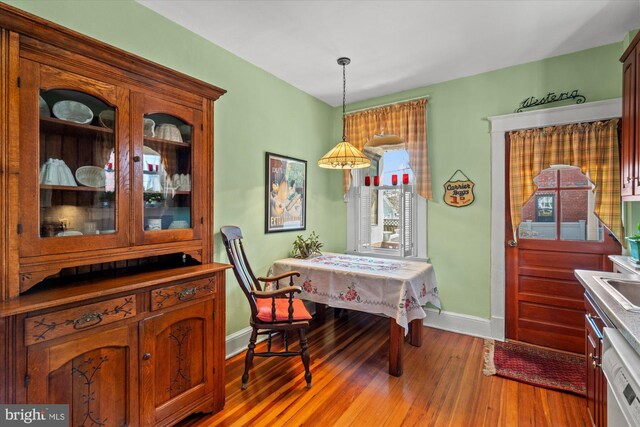 dining space featuring light wood-style flooring and baseboards