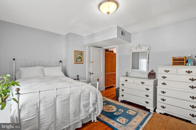 bedroom featuring wood finished floors and visible vents