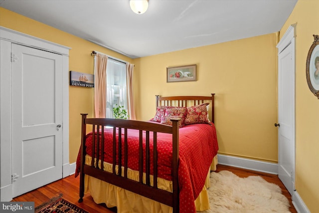 bedroom with baseboards and wood finished floors