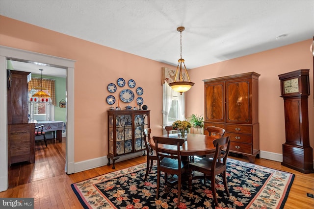 dining space featuring a wealth of natural light, light wood-type flooring, and baseboards